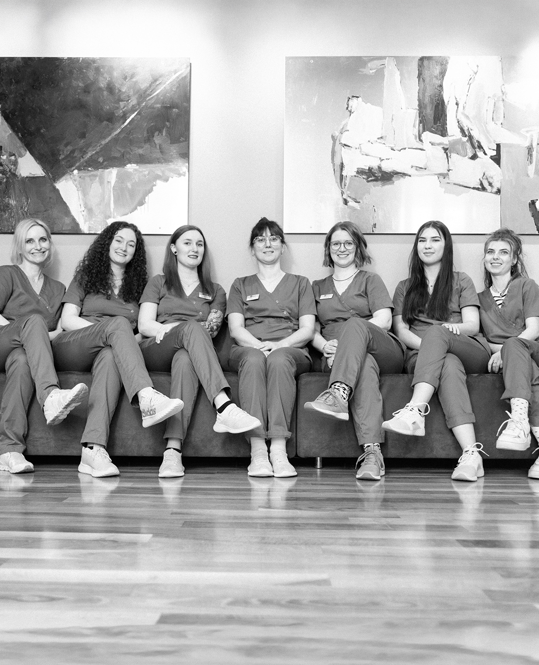 Team der Kieferorthopaedie Erwachsene Deggendorf sitzt gemeinsam in der Praxis