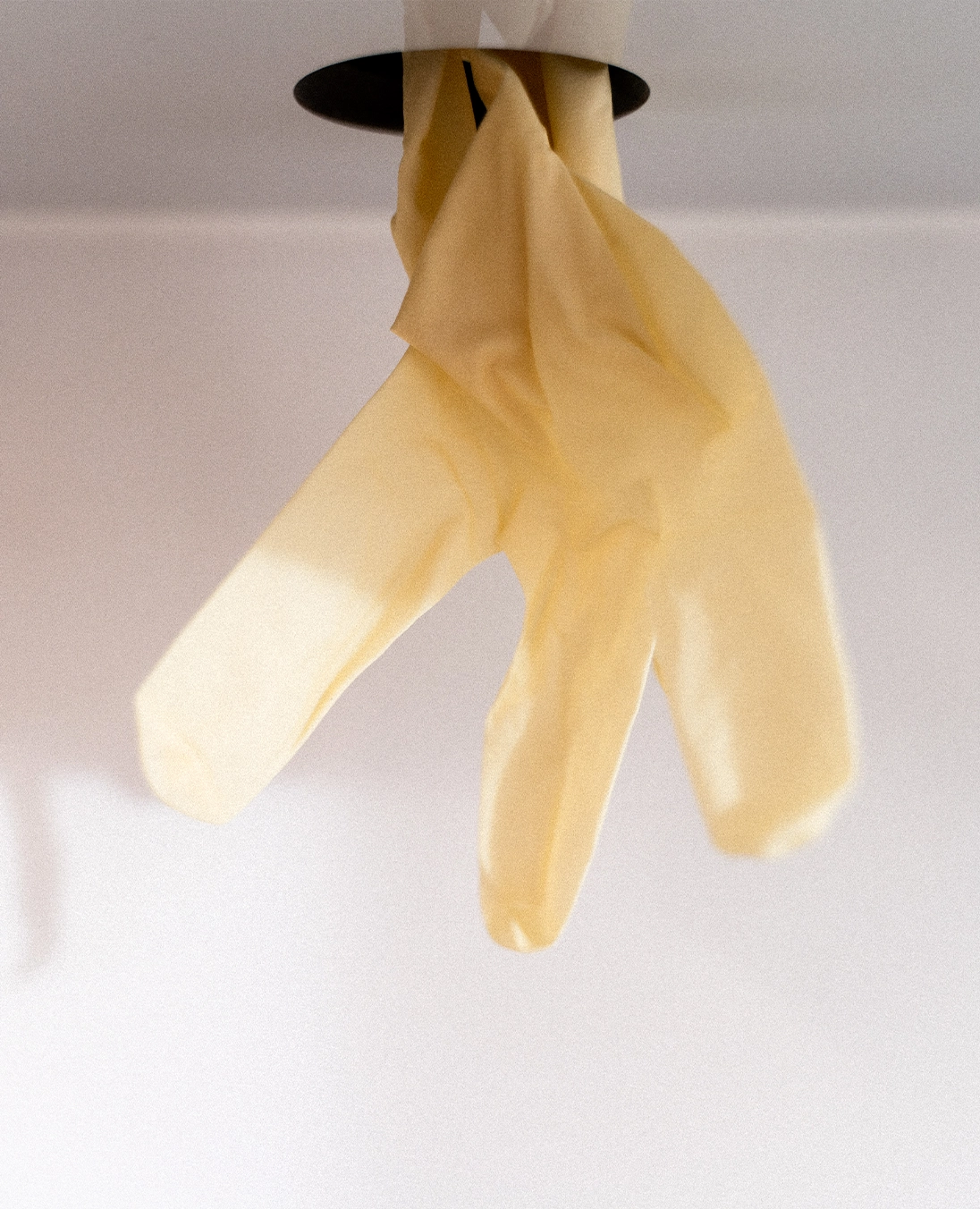 Einmalhandschuh hängt an einer Halterung in einer Praxis