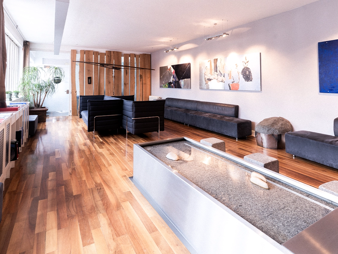 Moderner Wartebereich einer Praxis mit Sitzgelegenheiten und Kunst