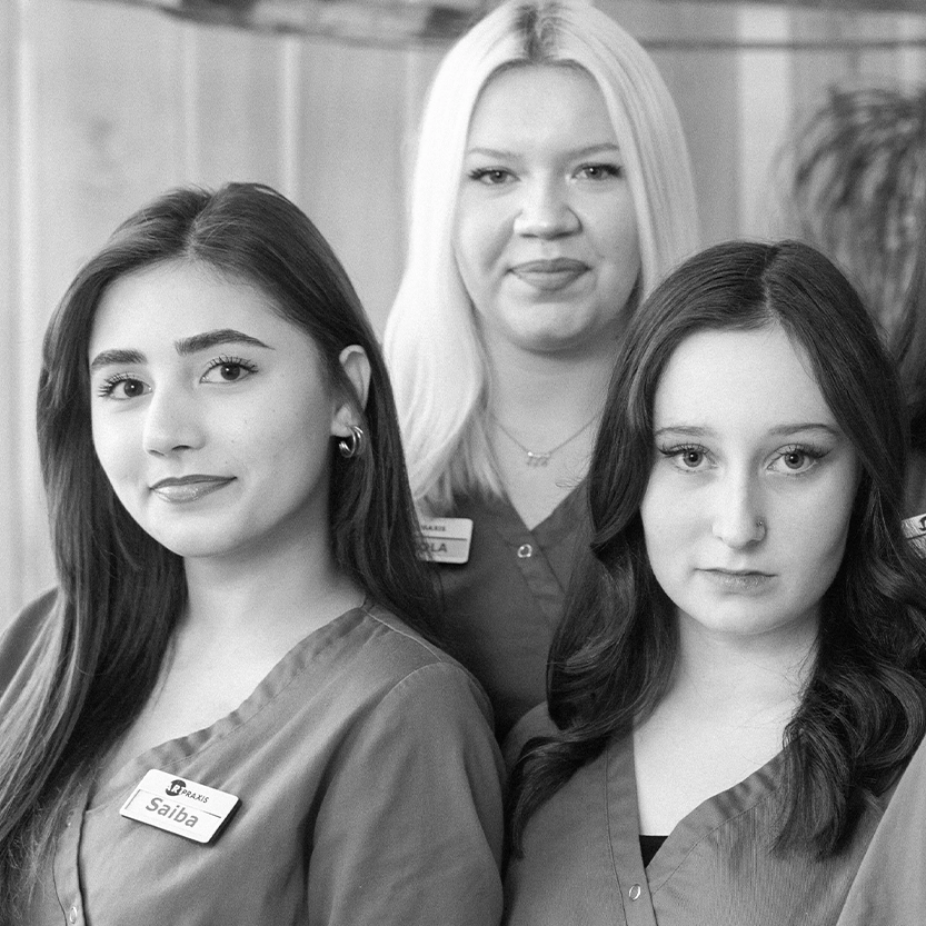 Drei Auszubildende in Praxiskleidung im Team der Kieferorthopädie