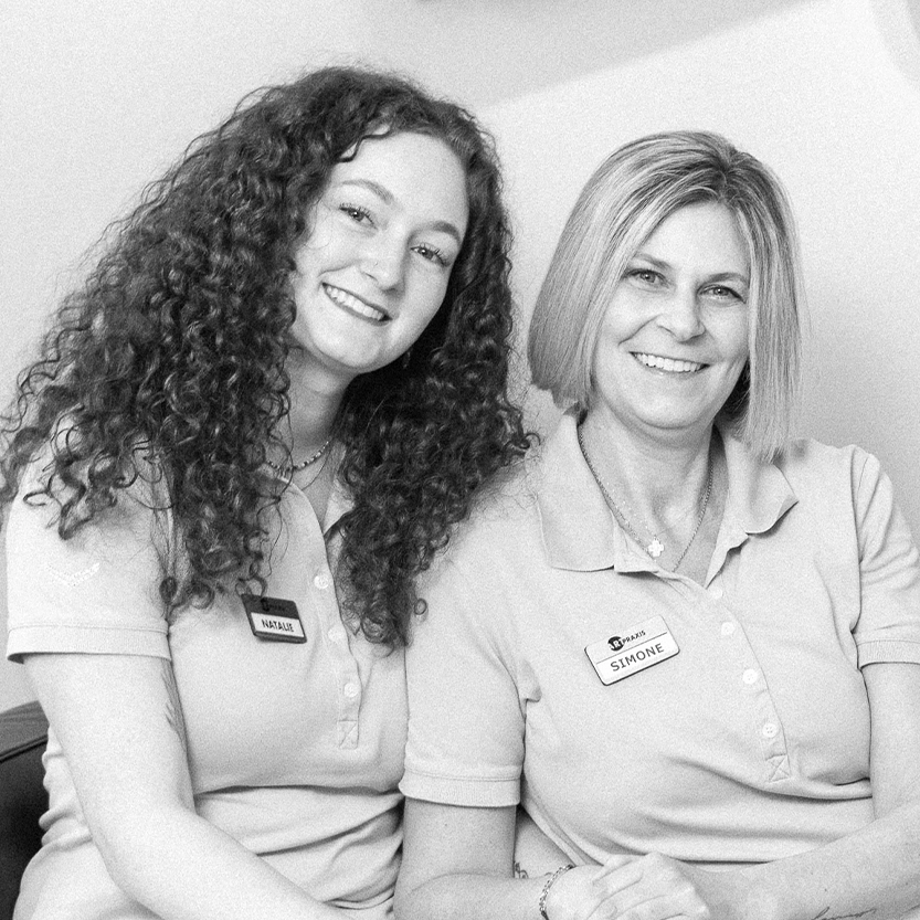 Zwei Mitarbeiterinnen der Praxis in freundlicher Pose