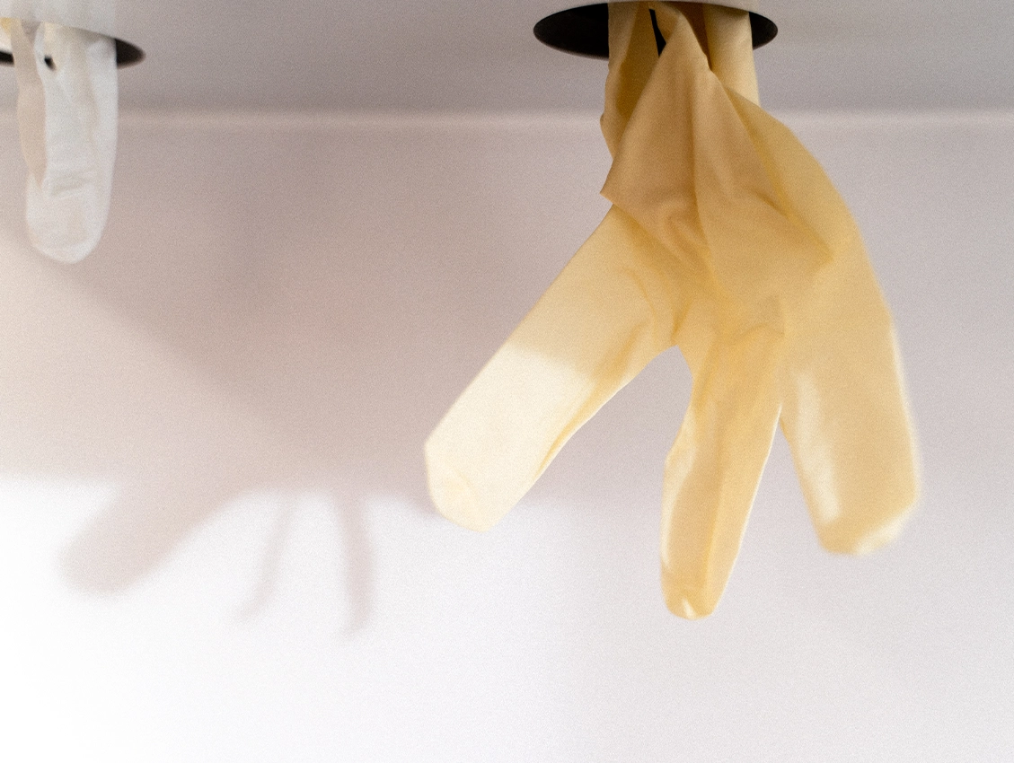 Einweghandschuhe hängen griffbereit in der Zahnarztpraxis