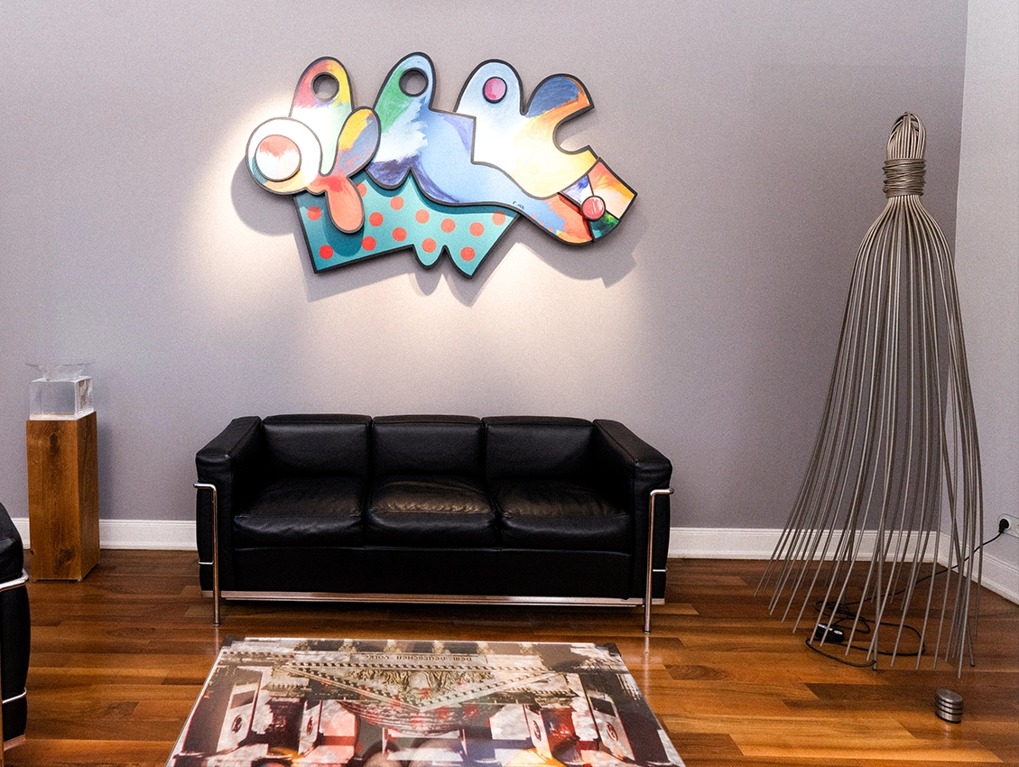 Wartebereich einer Praxis mit Sofa und farbigem Kunstwerk an der Wand