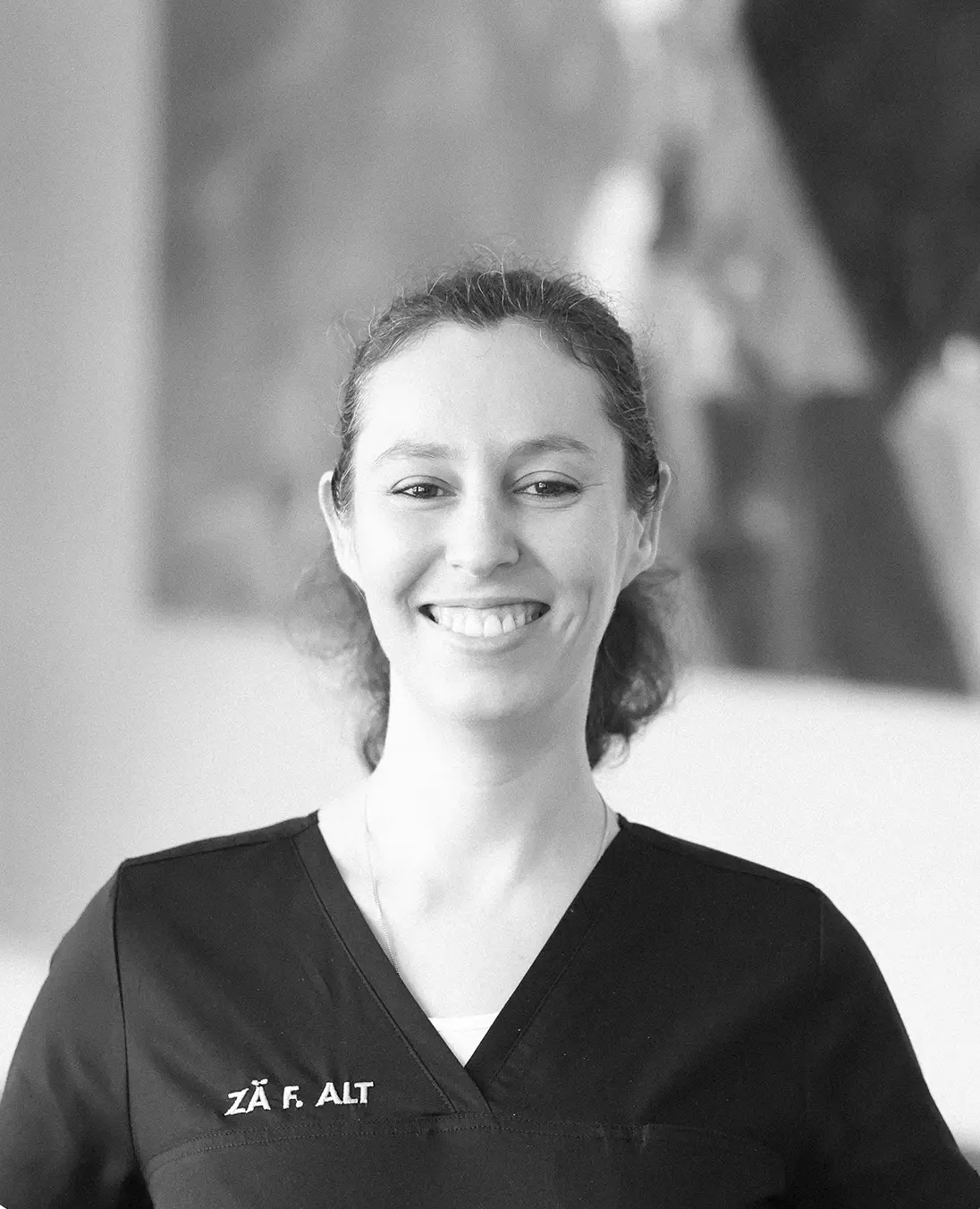 Felicitas Alt lächelt in die Kamera und trägt ihre Arbeitskleidung in der ART PRAXIS Deggendorf.